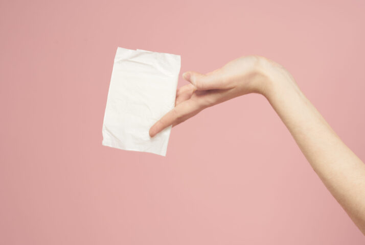 Laying in packaging in female hands on a pink background cropped view hygiene clean appearance. High quality photo